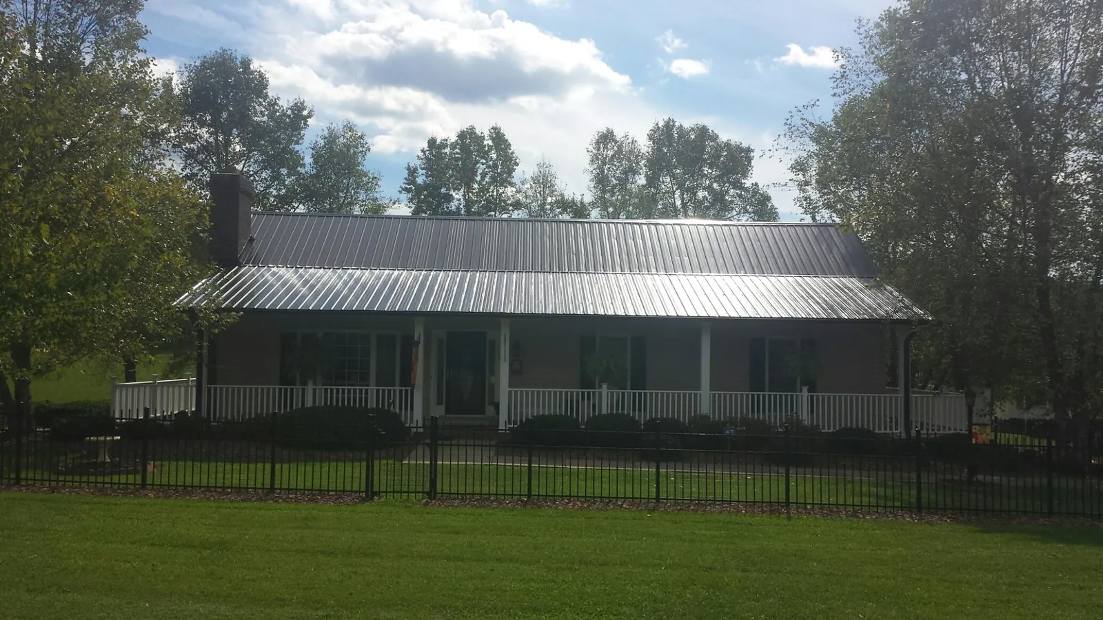 Gray metal roof on a brick ranch with a full width front porch — Gutter Guard Installation work by our crew in El Sobrante